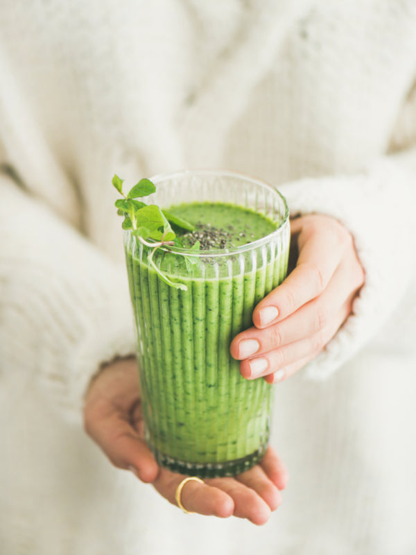 Woman holding green smoothie